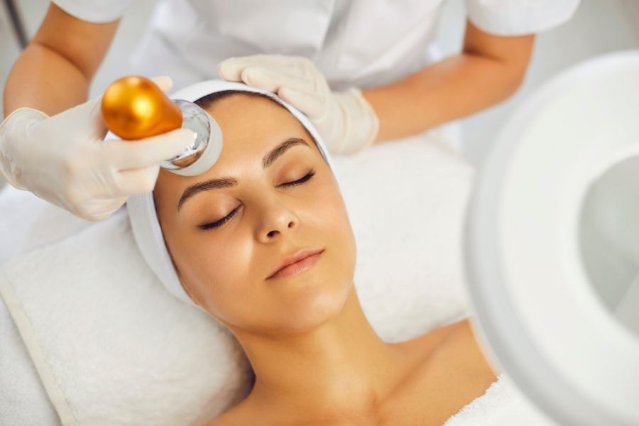 Traitement de radiofréquence fractionnée sur le visage d'une femme en institut esthétique