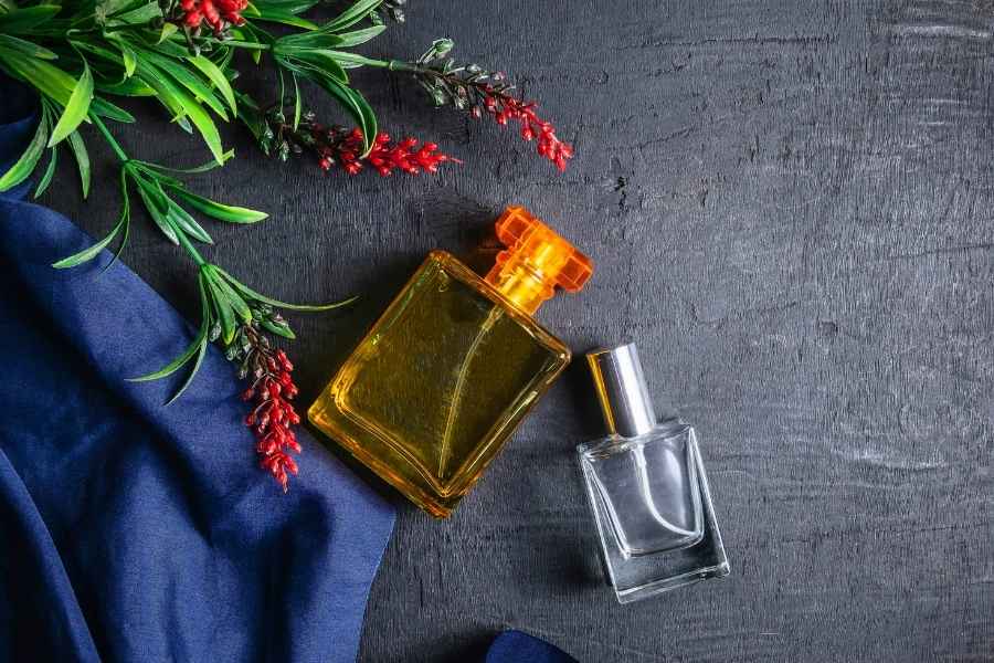 Flacons de parfum artisanaux dorés et transparents avec éléments botaniques, essence de la parfumerie de niche